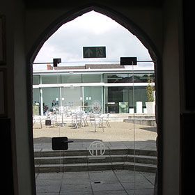 Arched glass double doorway looking out onto patio area with tables and chairs