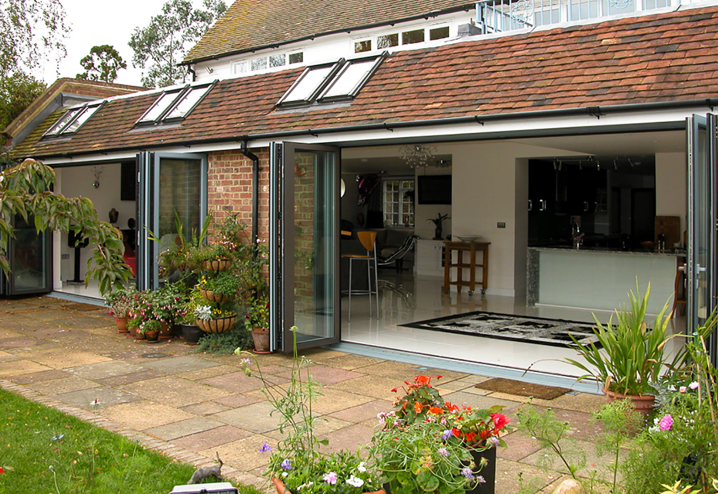 Contemporary styled modern aluminium sliding doors opening onto a beautiful garden with a swimming pool